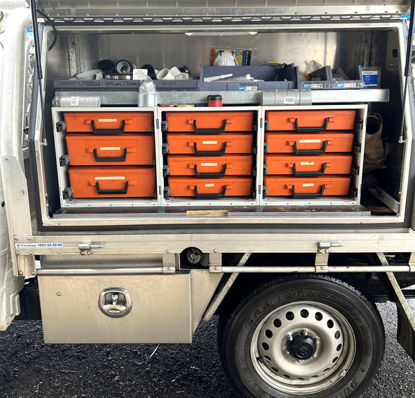 Open tool box with orange drawers on a vehicle