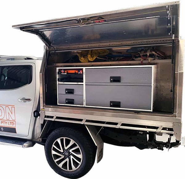 Truck with an open storage compartment featuring drawers and a cabinet.