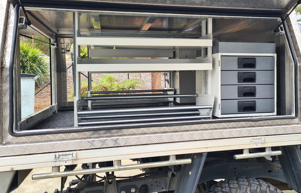 Open RolaCase storage compartment of a vehicle with shelves and drawers.