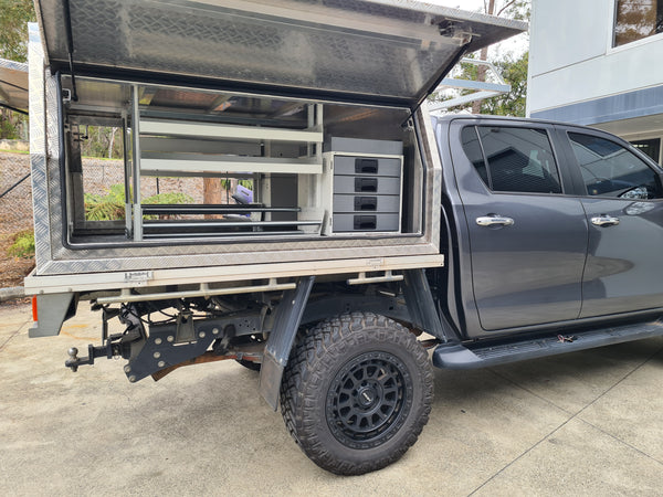 Rolacase Gray truck with an open bed featuring storage compartments and a window.
