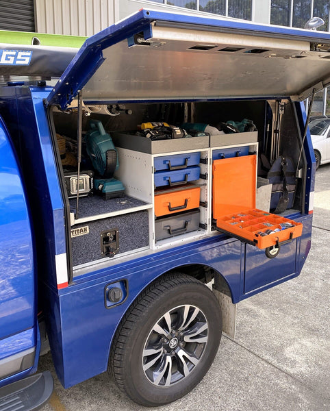 Blue van with open tool compartment containing various tools and equipment.